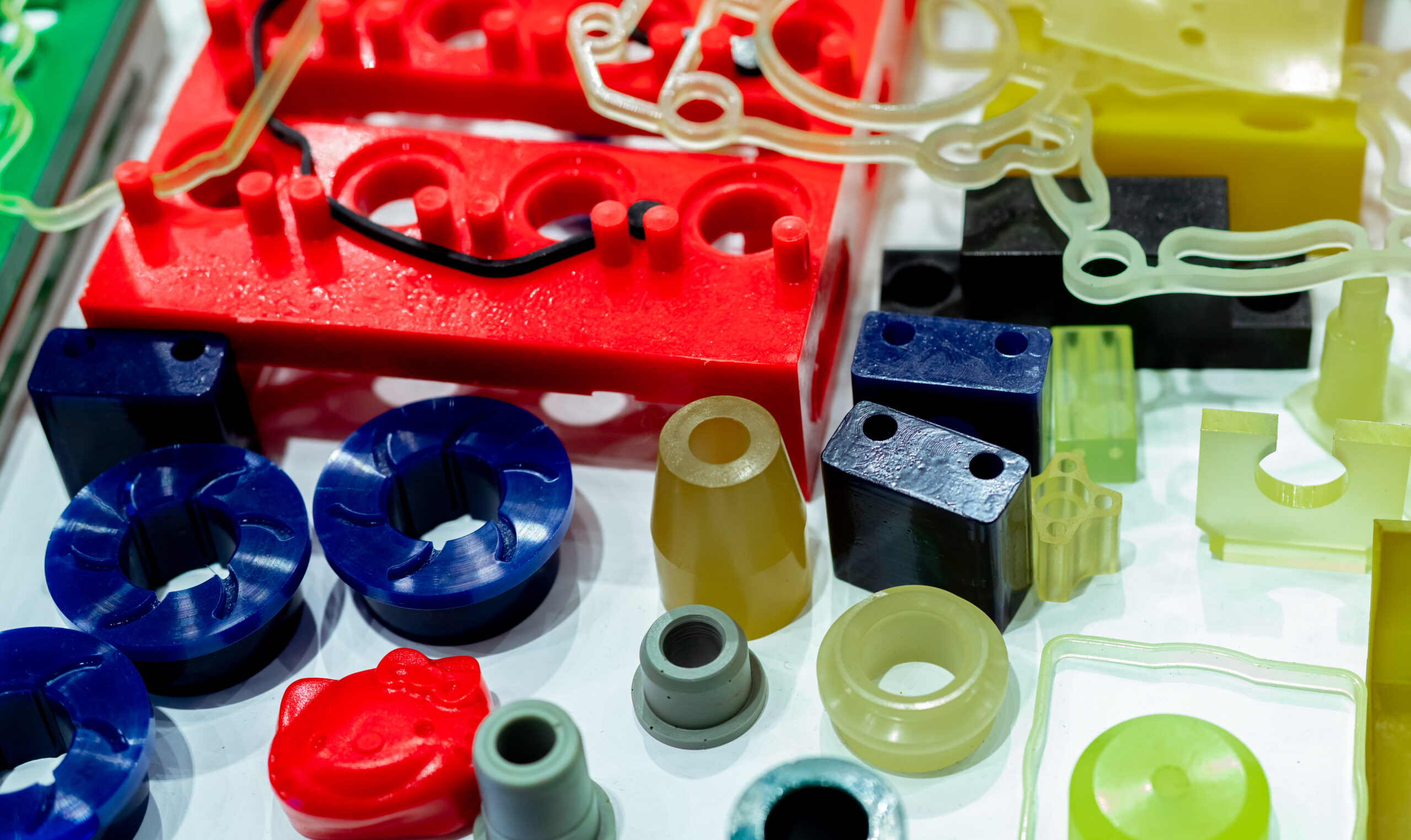 A variety of colorful thermoplastic elastomer (TPE), thermoplastic polyurethane (TPU), and Santoprene parts sitting together on display.